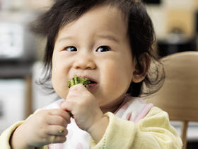Cover-baby eating broccoli.