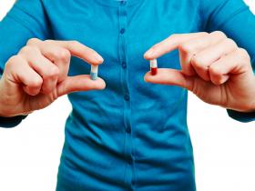 Man holding two pills