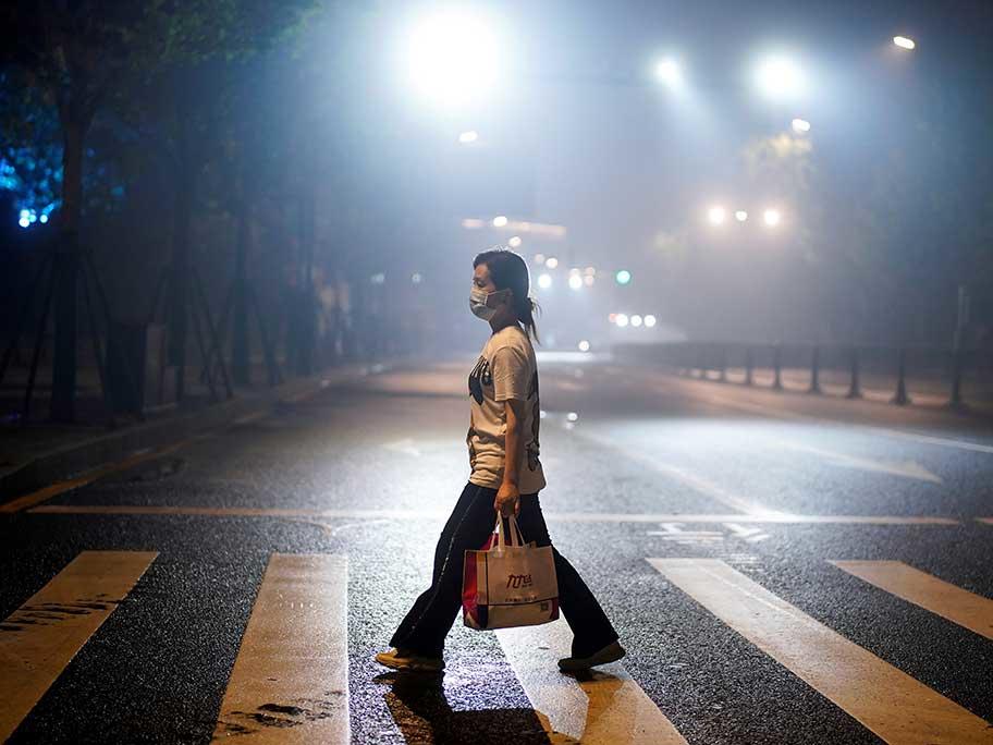 A woman walks on a street in Wuhan, China.