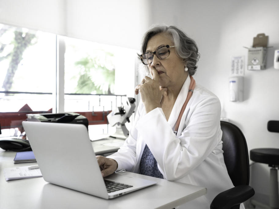 female consultant gastroenterologist looking at her laptop