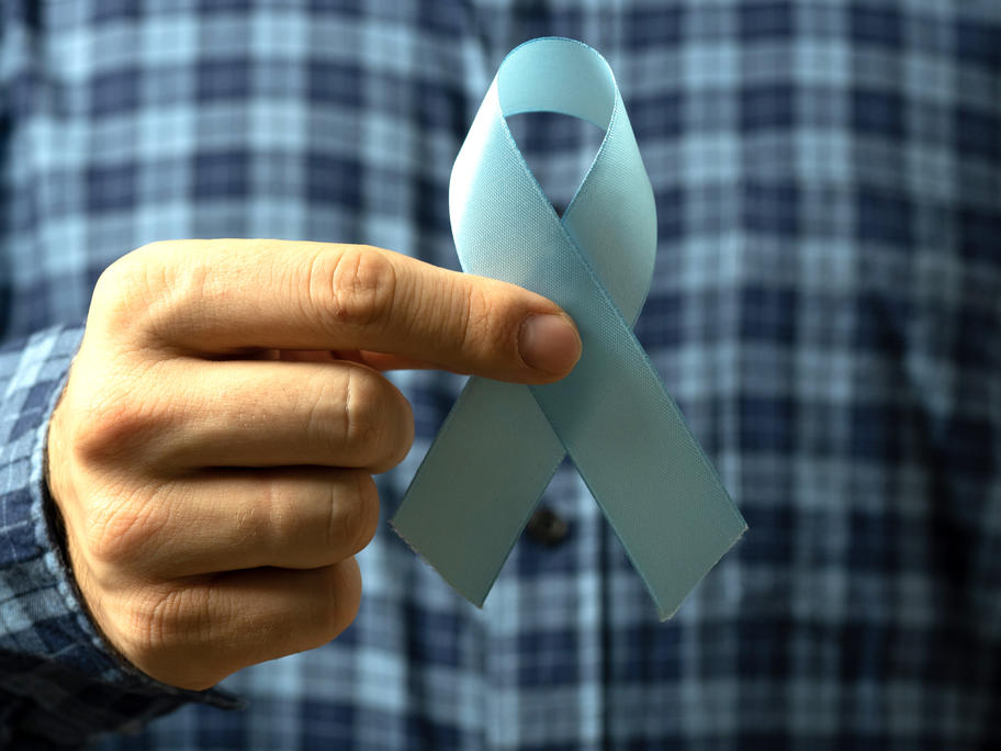 man in checked shirt holding blue ribbon