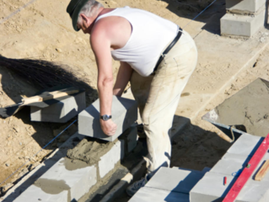 builder laying heavy blocks