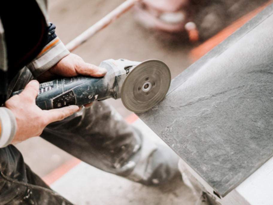Stone mason cutting stone slab