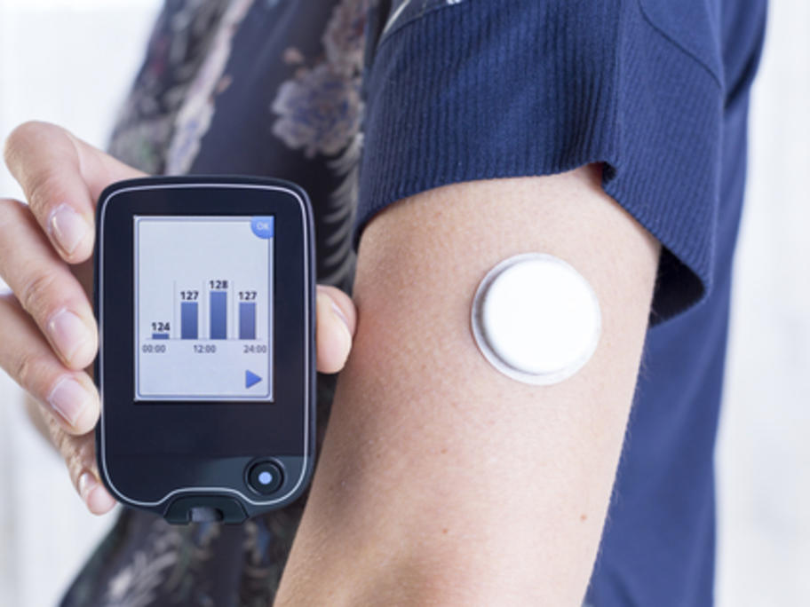 young woman using flash glucose monitoring device