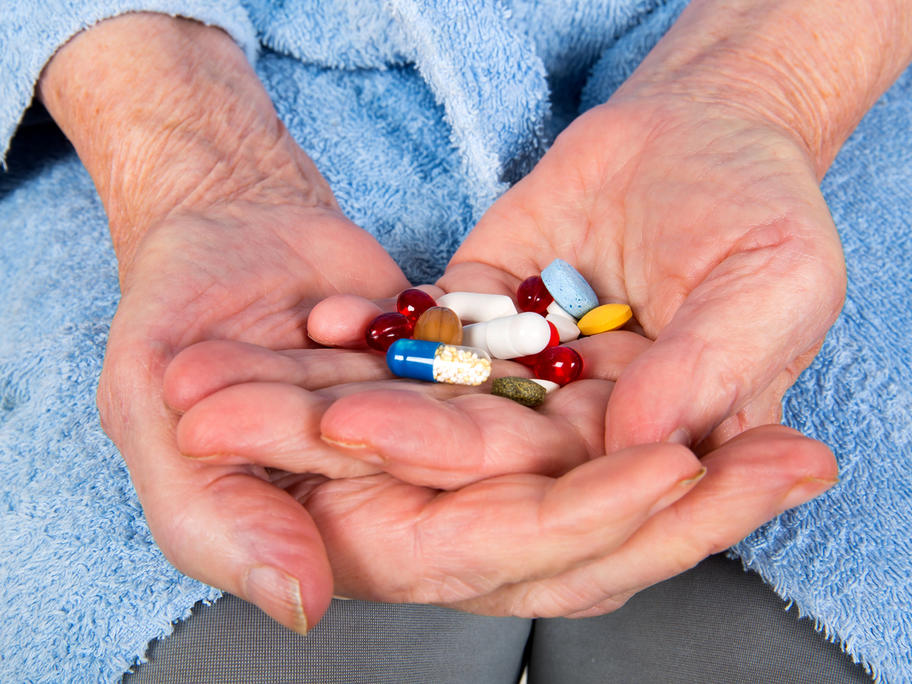 Elderly hands holding lots of medication