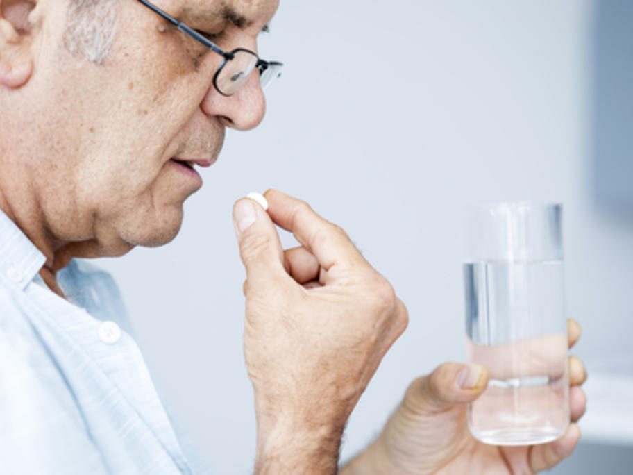 senior man taking pills