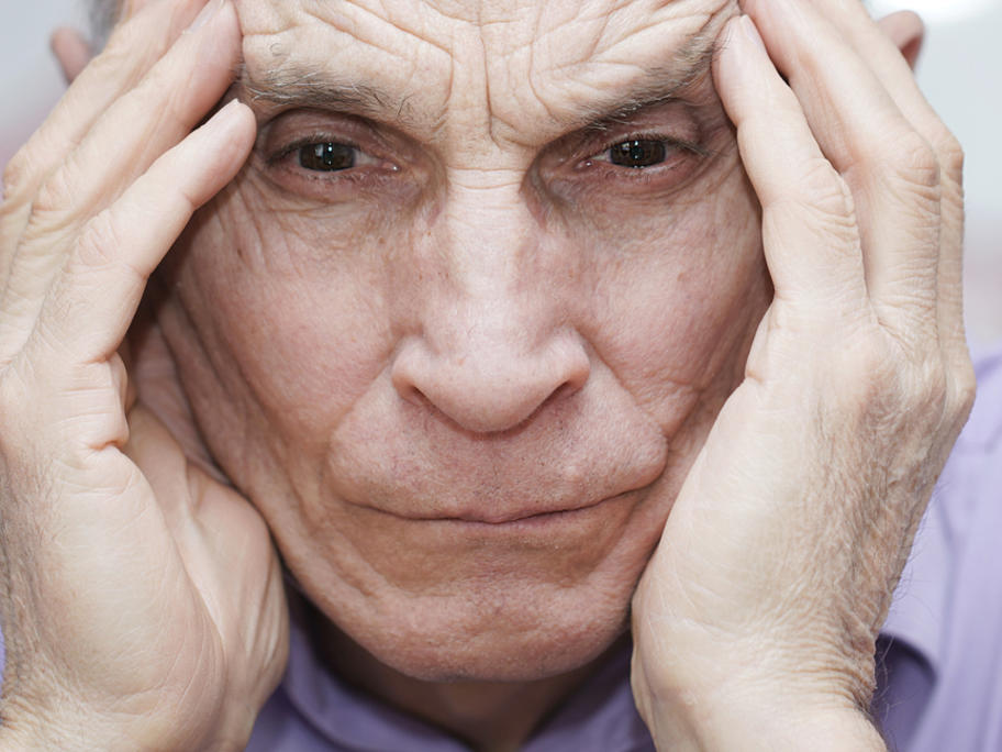 old man holding his head in his hands