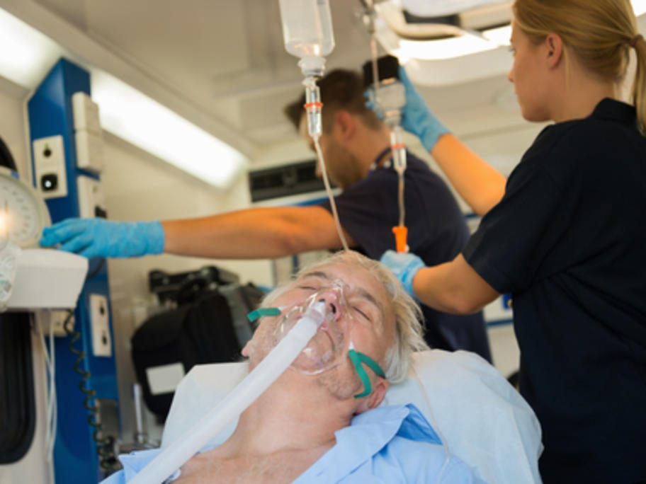 senior man being given oxygen by paramedics