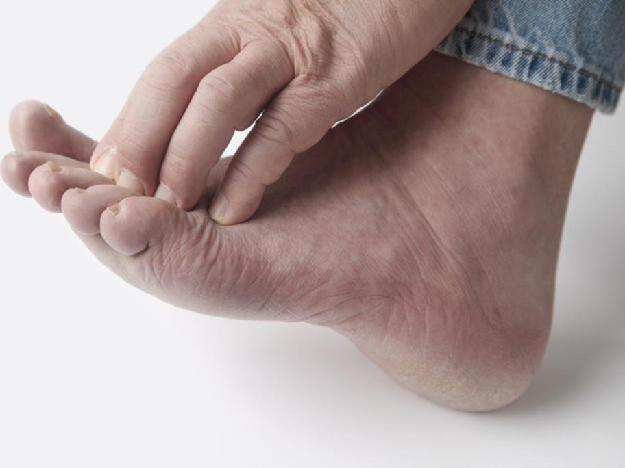 man holding a painful foot