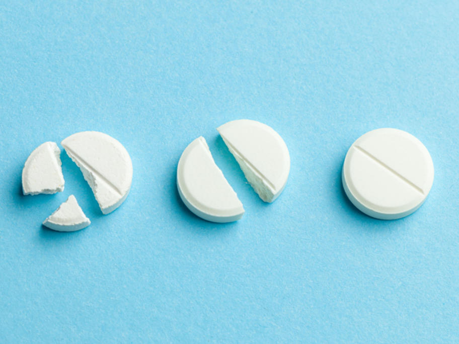 pills broken into halves, quarters - concept of dose