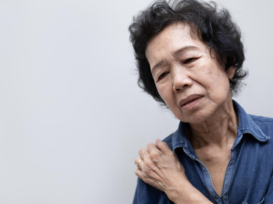 Senior Asian woman holding painful shoulder