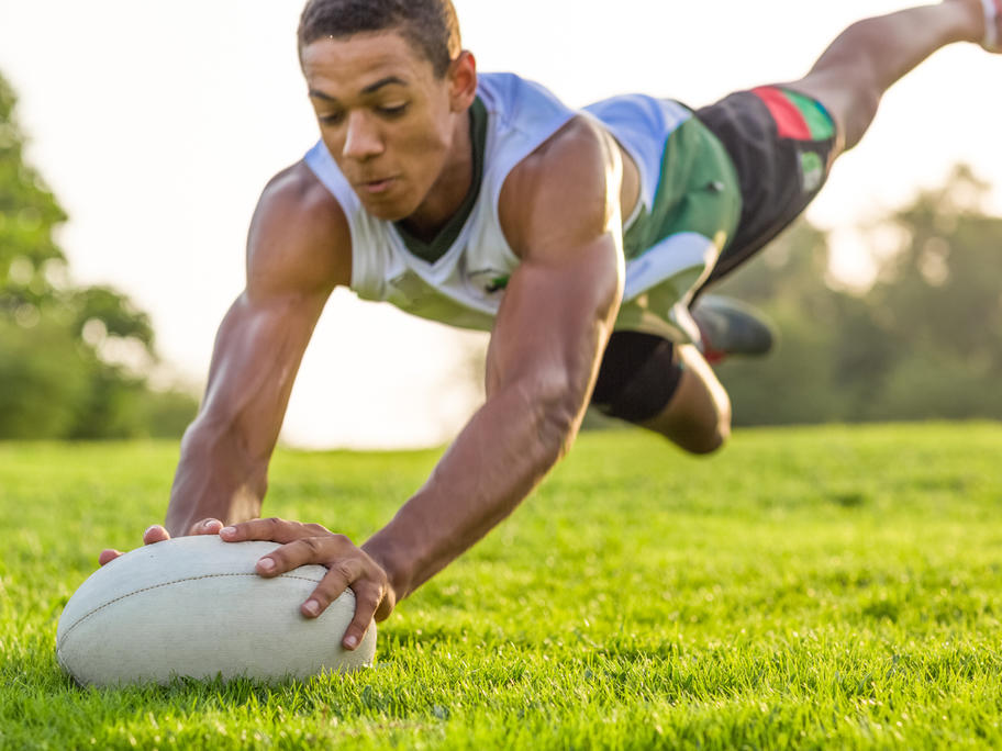 Young man scoring a try in rugby
