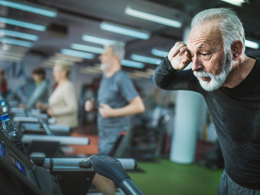senior man looking tired on exercise treadmill