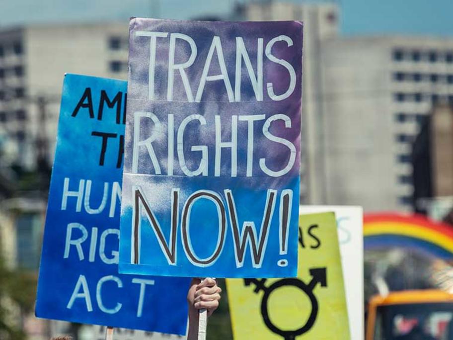 A pride parade makes its way through a city street