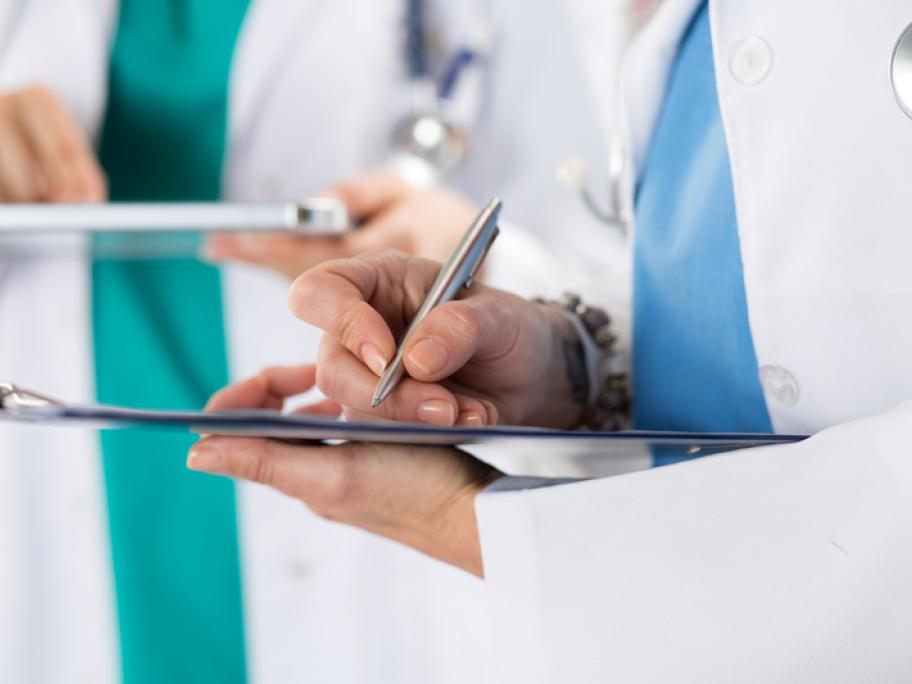 doctors recording information on clipboard and tablet