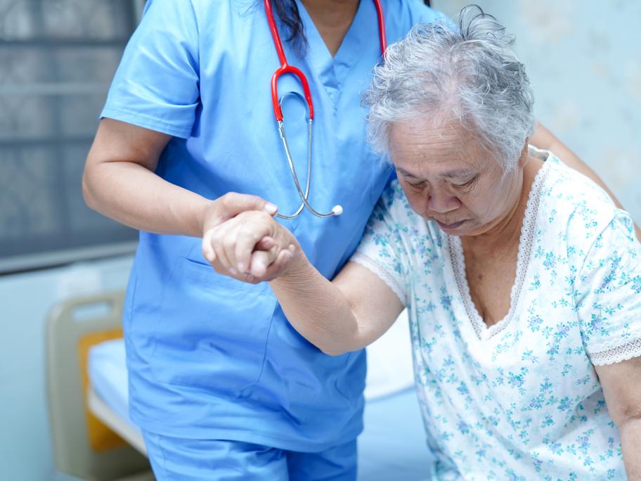 Elderly woman being helped