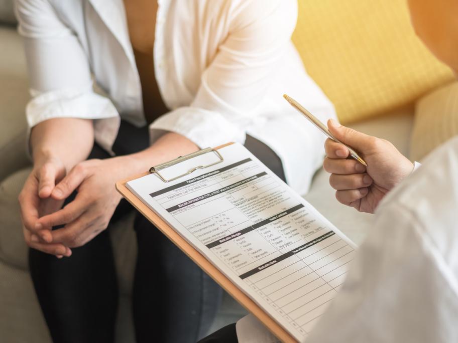 patient having somethign explained to her by doctor with clipboard
