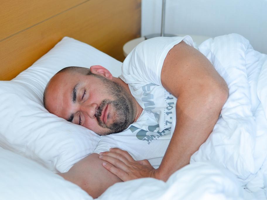 man in his 60s asleep in bed