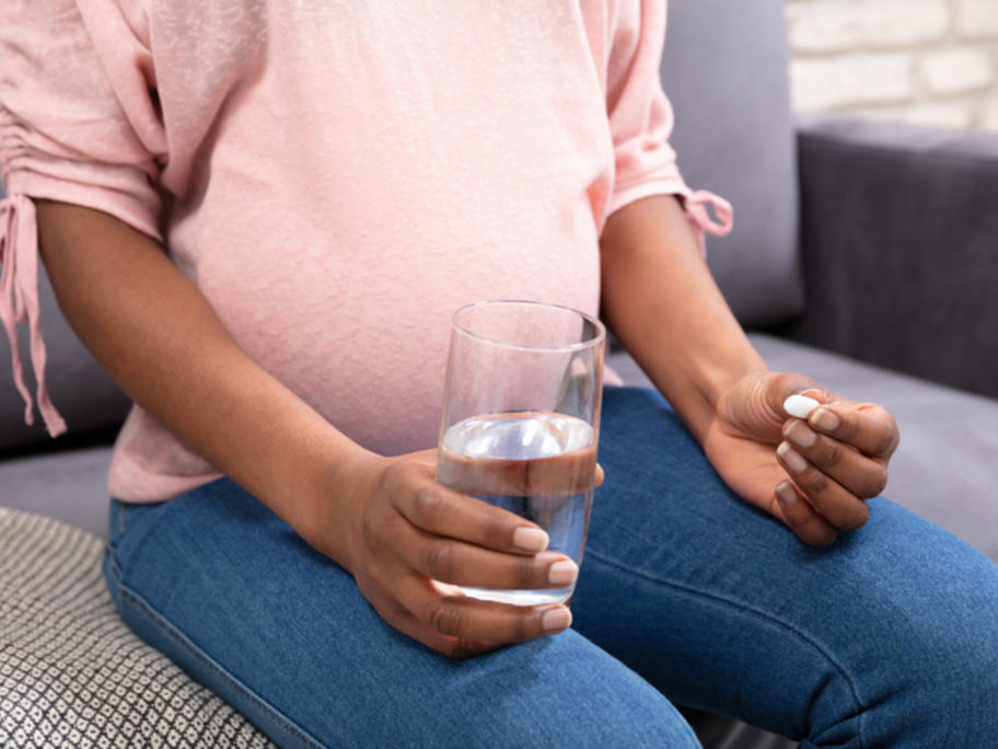 Pregnant woman taking a pill