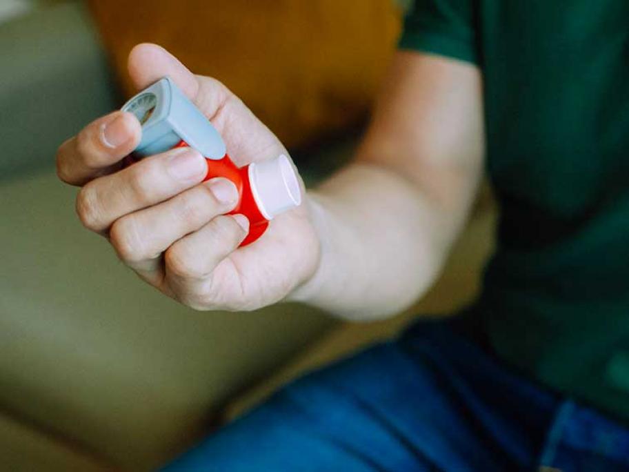 young man holding combination inhaler