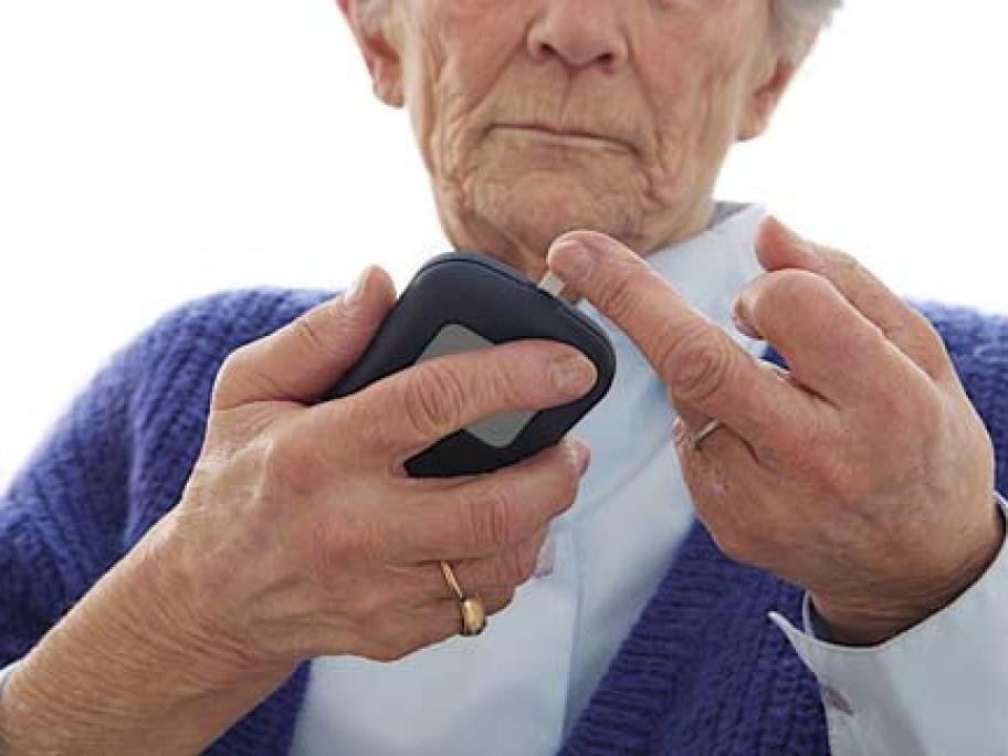 woman in her 70s doing a glucose prick test