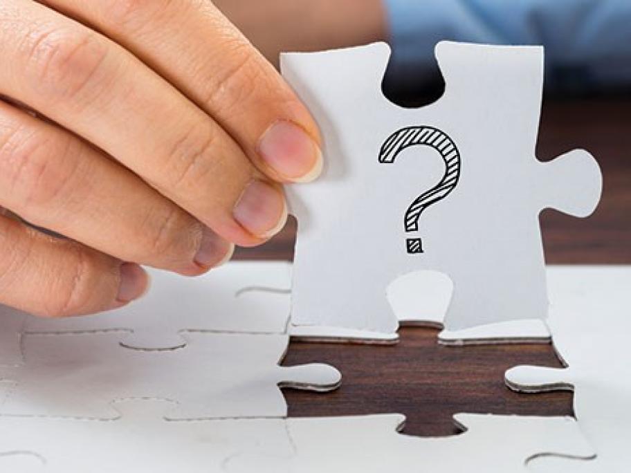 man holding jigsaw puzzle with question mark on it