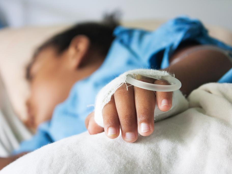 young child with IV drip in hospital