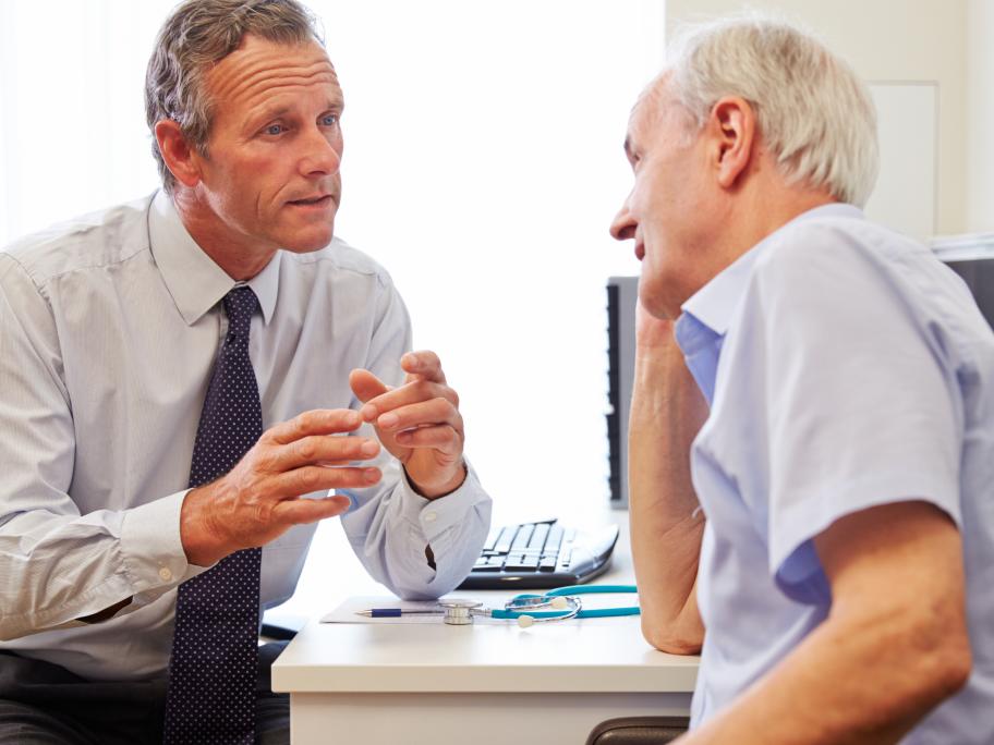 Doctor talking earnestly to patient - a man in his 70s