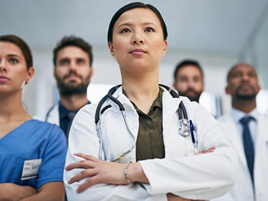 young female hospital doctor with other doctors behind